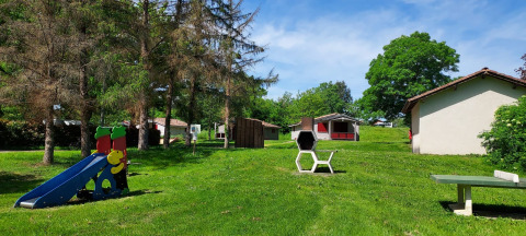 Speeltuin, grasveld en chalets bij Onlycamp Camping de l'Argenté in Occitanië, Frankrijk, met mooi weer.