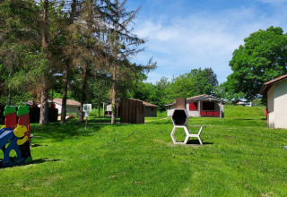 Speeltuin, grasveld en chalets bij Onlycamp Camping de l'Argenté in Occitanië, Frankrijk, met mooi weer.
