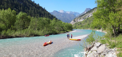 Personas navegando en kayak por un río claro rodeado de montañas cerca de Vercheny, Auvergne-Rhône-Alpes, Francia.