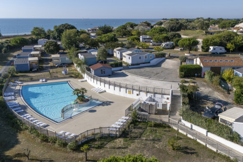 Aerial view of Flower Camping Le Platin - La Redoute holiday park with pool, mobile homes, and sea view.