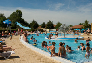 Families swimming, playing, and relaxing on loungers at the sunny Onlycamp Camping le Champ d’Eté holiday park, France.