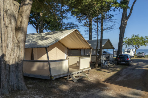 Telthytter og campingvogne blandt træer på Flower Camping Le Platin - La Redoute, Île de France, Frankrig.