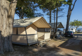 Tent lodges and campers under trees at Flower Camping Le Platin - La Redoute, Île de France, France.