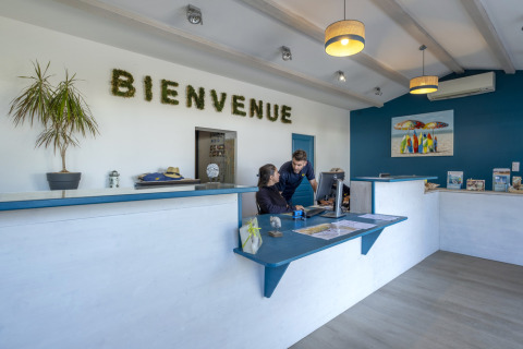 Helle Rezeption mit Begrüßungsschild 'BIENVENUE' bei Flower Camping Le Platin - La Redoute in Île de France.