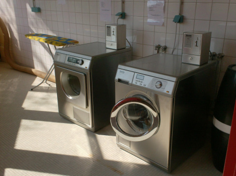 Coin-operated washing machine and dryer at Onlycamp Camping de Besançon holiday park in France.
