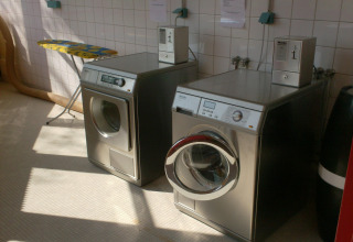 Coin-operated washing machine and dryer at Onlycamp Camping de Besançon holiday park in France.