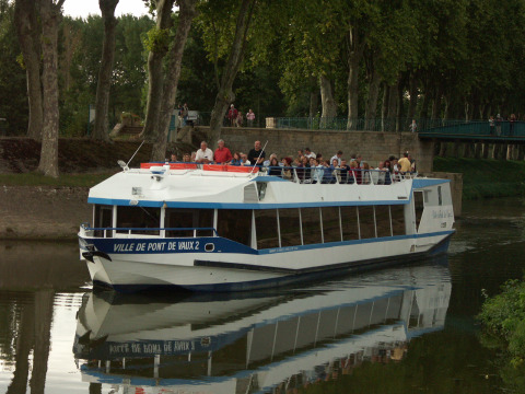 Rondvaartboot met passagiers vaart door een kanaal nabij Reyssouze in Auvergne-Rhône-Alpes, Frankrijk.