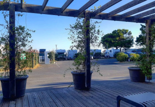 Wooden terrace overlooking potted plants and parked RVs at Flower Camping Le Platin in Île de France, France.