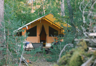 Et stort, moderne telt midt i en grøn skov i Camping Onlycamp Les Pins, Centre-Val de Loire, Frankrig.