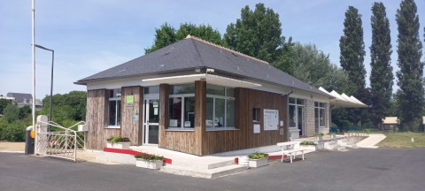Eingangsbereich von Onlycamp Camping La Gâtine in Centre-Val de Loire, Frankreich, mit Bänken und Pflanzen.