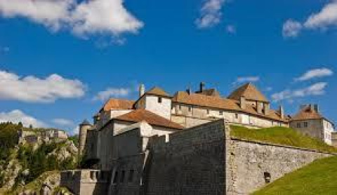 A photo of a historic fortress with red rooftops and stone walls at Onlycamp Camping de Besançon, Bourgogne-Franche-Comté, France.