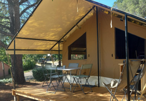 Tenda safari Ponza con terrazza coperta, mobili da esterno e ambiente naturale in campeggio.