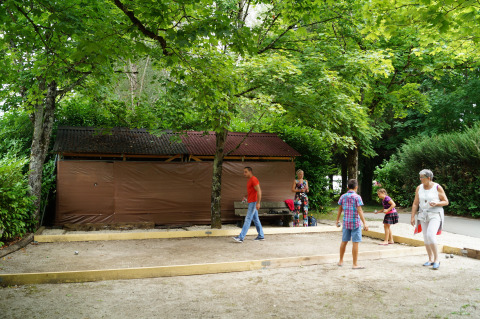Folk nyder fritiden og spiller petanque i Onlycamp Camping de Besançon i Bourgogne-Franche-Comté, Frankrig.