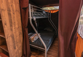 Vista interior de la tienda safari Tiny-house Galli en Onlycamp Camping La Gâtine, Francia, con litera de metal.