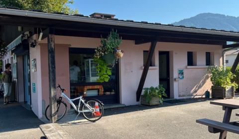Buitenaanzicht van Onlycamp Camping Les Thézières met fiets, planten en bergen op de achtergrond.