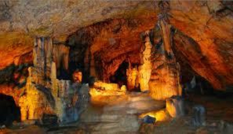 Beleuchtete Tropfsteinhöhle in der Nähe von Chalezeule, Bourgogne-Franche-Comté, Frankreich, mit Stalaktiten und Stalagmiten.