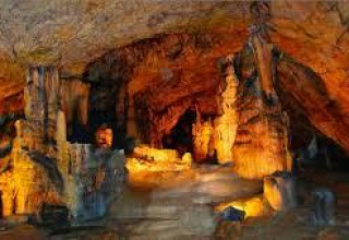 Beleuchtete Tropfsteinhöhle in der Nähe von Chalezeule, Bourgogne-Franche-Comté, Frankreich, mit Stalaktiten und Stalagmiten.