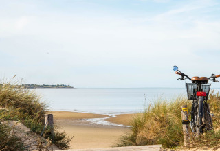Bicycle parked on a sandy path overlooking the beach and sea near Rivedoux-Plage, Île de France, France.