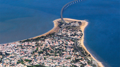 Luchtfoto van een kustdorp met een lange brug over het water bij Flower Camping Le Platin - La Redoute.