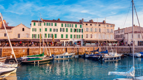 Havnefront med både og farverige bygninger ved Flower Camping Le Platin - La Redoute, Île de France.