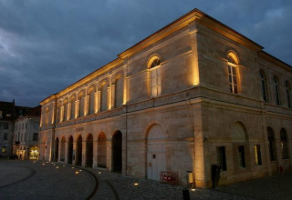 Beleuchtetes historisches Gebäude am Abend im Onlycamp Camping de Besançon, Bourgogne-Franche-Comté, Frankreich.