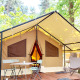 Spacious glamping tent with deck, table and chairs, surrounded by green forest and natural sunlight.