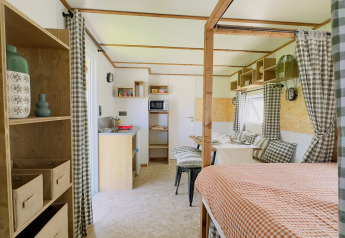 Interior del lodge Karlotte Zeezicht Premium en Flower Camping Le Platin - La Redoute, Francia, decoración acogedora.