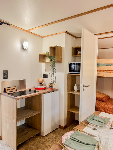Cozy kitchenette and dining area in a lodge at Flower Camping Le Platin - La Redoute, France, with bunk beds.