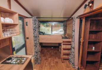 Interno della tenda safari Galli Tiny-house presso Onlycamp Camping Les Tuillères in Francia con arredi in legno.
