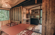 Interieur van safari tent Galli Tiny-house op Onlycamp Camping Les Tuillères in Frankrijk met keuken en eetruimte.