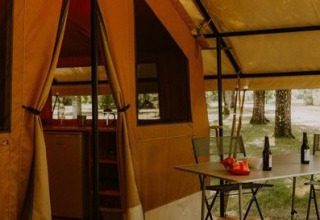 Safari telt Ponza ved Onlycamp Camping le Champ d'Eté i Frankrig med bord, stole og flasker foran.