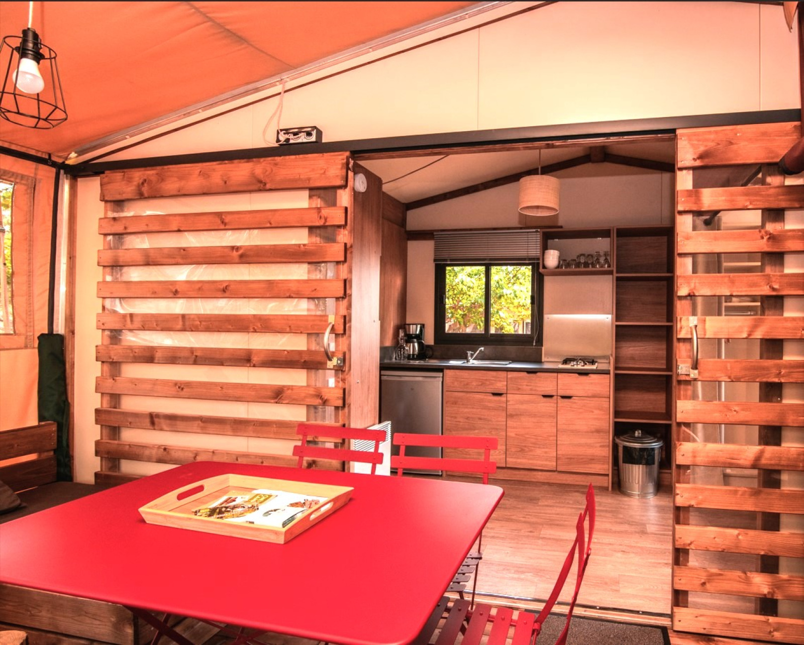 Interieur van de Tiny-house Galli safaritent met keuken en eettafel op Camping Chamarges in Frankrijk.