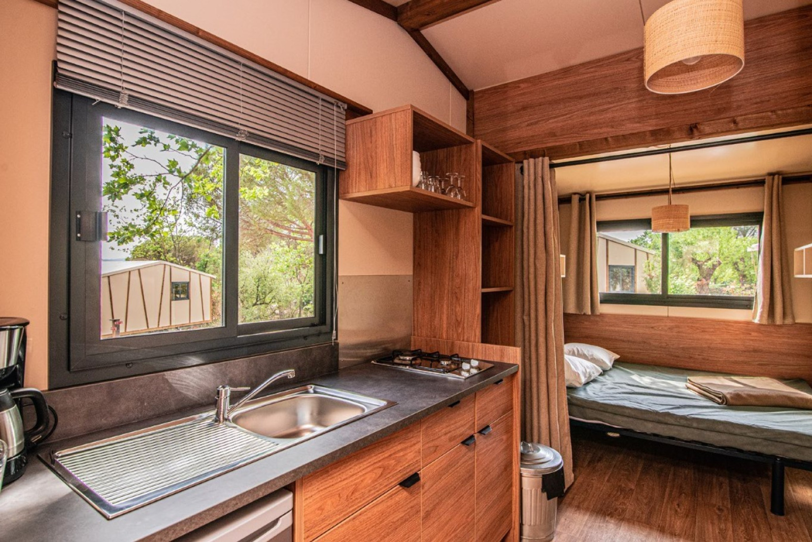 Interieur van de safaritent Tiny-house Galli op Onlycamp Camping Chamarges in Frankrijk, met keuken en bed.