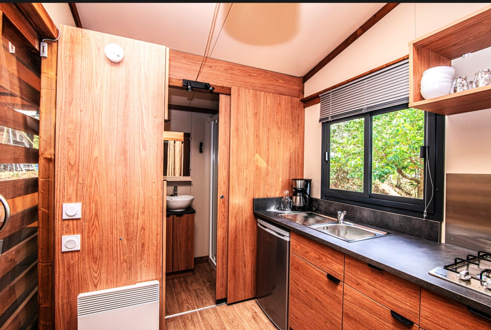 Moderne houten keuken en badkamer in een safaritent bij Tiny-house Galli, Onlycamp Chamarges, Frankrijk.