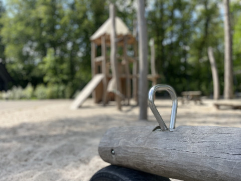 Un parco giochi con strutture in legno e sabbia, fotografato all'Holiday park Latour nel Brabante Settentrionale, Paesi Bassi.
