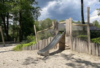 Parque infantil con tobogán en Holiday park Latour, rodeado de árboles en Noord-Brabant, Países Bajos.