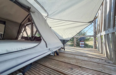 Glamping at Dachzelt Dorf Sandstedt in Lower Saxony, showing a roof tent setup with wooden deck.