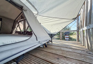 Glamping at Dachzelt Dorf Sandstedt in Lower Saxony, showing a roof tent setup with wooden deck.