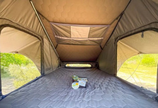 Interior view of a cozy rooftop glamping tent at Dachzelt Dorf Sandstedt in Lower Saxony, Germany.