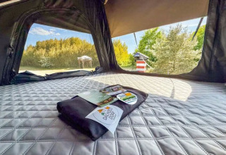 Intérieur d'une tente glamping à Dachzelt Dorf Sandstedt en Basse-Saxe, vue sur la nature verdoyante.