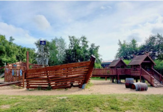 Spielplatz mit Piratenschiff bei Dachzelt Dorf Sandstedt Glamping in Niedersachsen, umgeben von Bäumen.