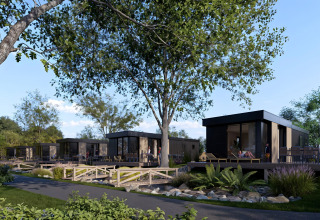 Moderne lodges met hottub aan Valkhof in Veluwe park de Bosgraaf, Nederland, omringd door bomen en natuur.