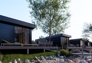 Lodges modernos con terraza de madera y tumbonas junto a un arroyo en Valkhof met Hottub, parque Veluwe.