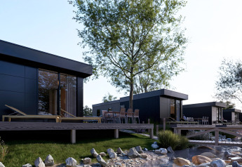 Moderne lodges med træterrasse, udendørs stole og naturskøn udsigt ved Valkhof met Hottub i Veluwe park.