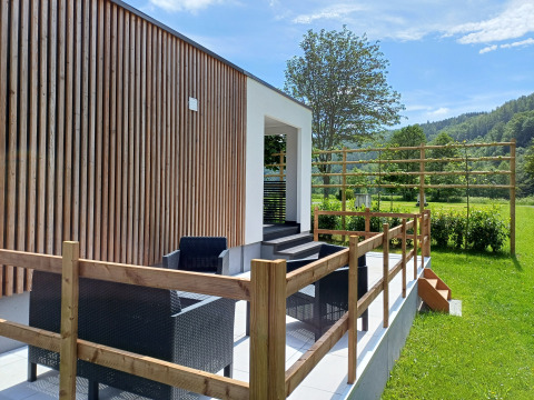 Buitenterras met zwarte tuinmeubels bij Eco Lodge MOBLINA, Camping Floreal La Roche-en-Ardenne, België.