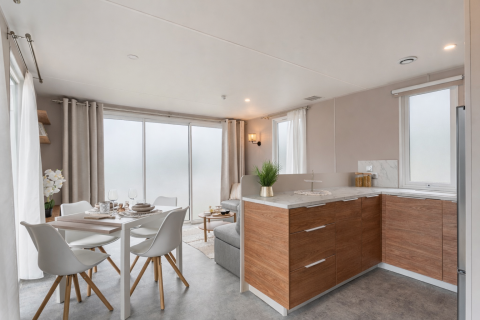 Chalet moderno con cucina e zona pranzo e ampie finestre al Vakantiehuis Deluxe di Camping Papillon, Belgio.