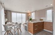 Chalet moderno con cucina e zona pranzo e ampie finestre al Vakantiehuis Deluxe di Camping Papillon, Belgio.