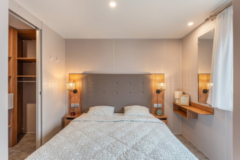 Camera moderna nel chalet Vakantiehuis Deluxe al Camping Papillon, Belgio, con letto matrimoniale e armadio.