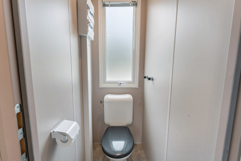 Bagno moderno con sedile grigio, finestra smerigliata in Vakantiehuis Deluxe al Camping Papillon in Belgio.