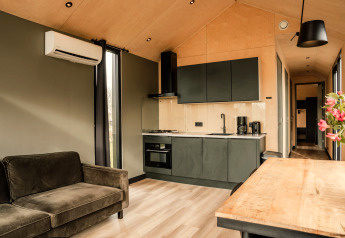 Moderne indretning i et tiny house på Holiday park Eigen Wijze i Holland med køkken og opholdsstue.